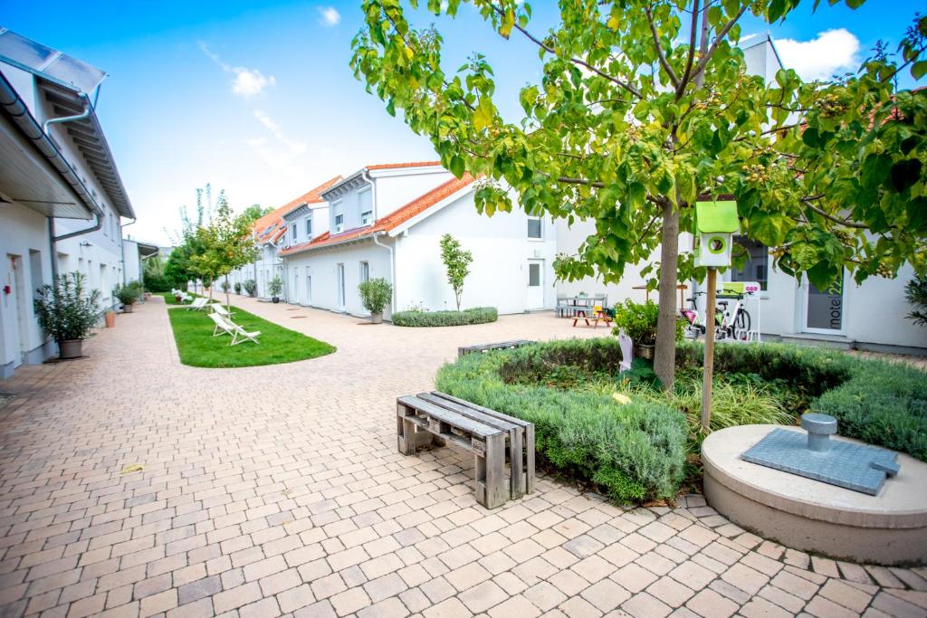 a park with a bench and a tree and buildings at motel22 Parkplatz inklusive in Vienna