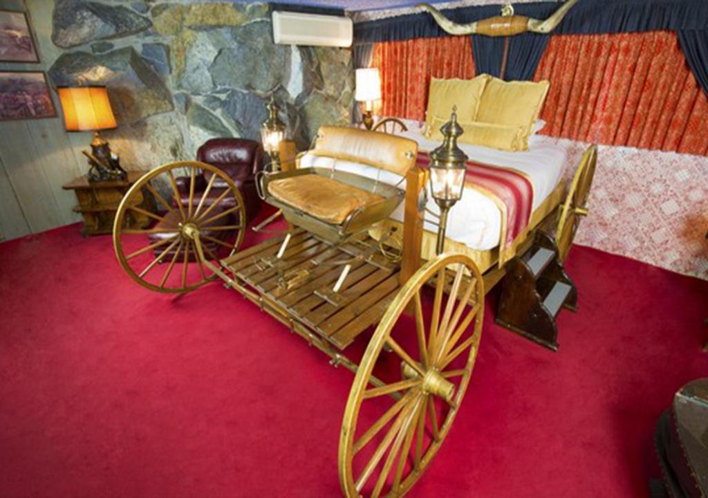 a bedroom with a bed and a horse drawn carriage at Madonna Inn in San Luis Obispo