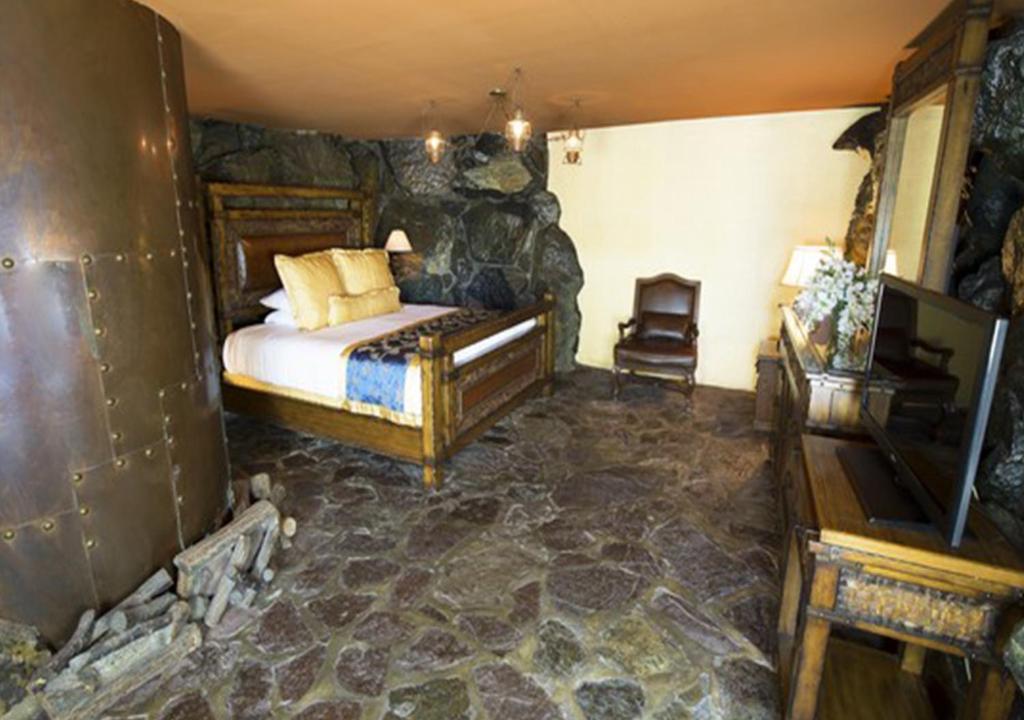 a bedroom with a bed in a room with rocks at Madonna Inn in San Luis Obispo
