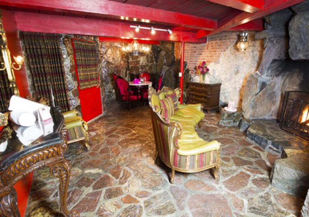 a living room with chairs and a stone fireplace at Madonna Inn in San Luis Obispo