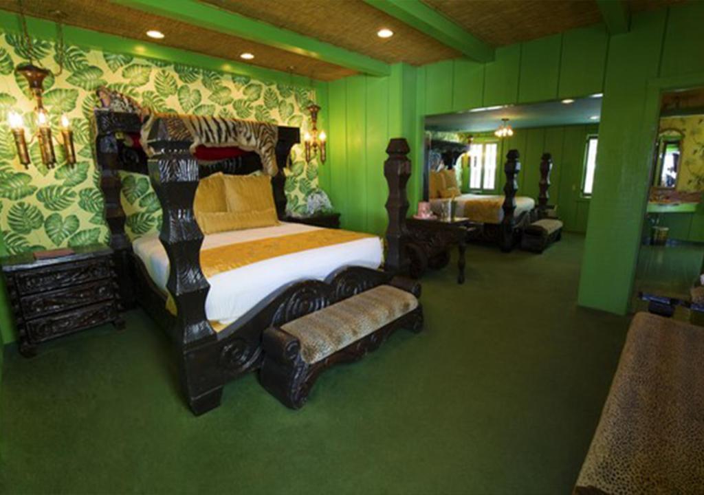 a bedroom with a large bed in a green room at Madonna Inn in San Luis Obispo