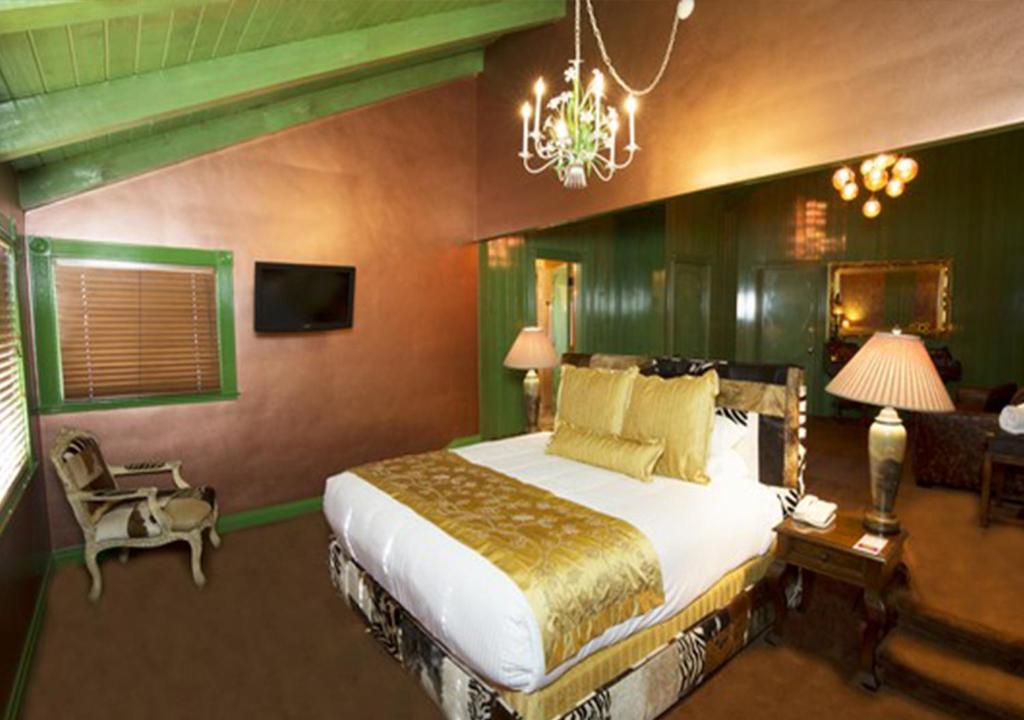 a bedroom with a large bed and a chandelier at Madonna Inn in San Luis Obispo