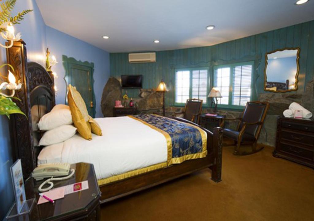 a bedroom with a large bed and a living room at Madonna Inn in San Luis Obispo