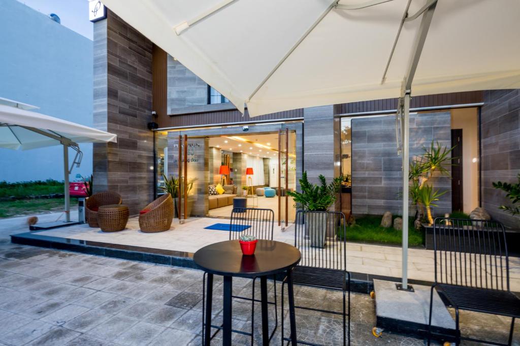 A shaded patio overlooks the hotel’s glass-fronted ground-floor interior.