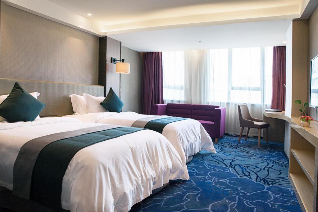 une chambre d'hôtel avec deux lits et une chaise dans l'établissement Zhongtian Mayfair Hotel - Bao'an International Airport Xixiang Subway Station, à Shenzhen