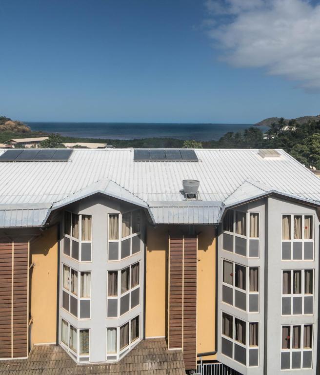 an apartment building with solar panels on the roof at Hotel Maharajah in Mamoudzou