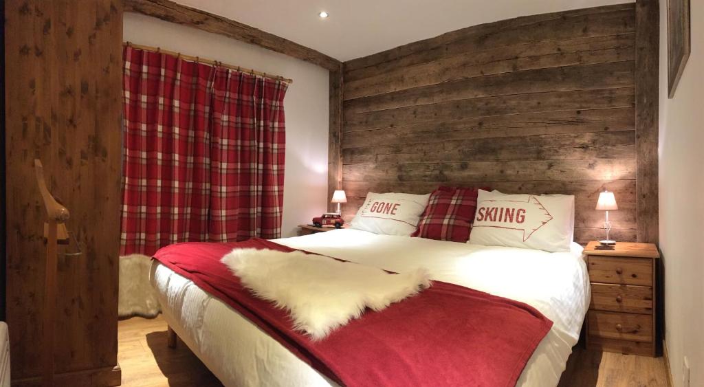 - une chambre dotée d'un lit avec une couverture rouge et blanche dans l'établissement Chalet JJ, à Sainte-Foy-Tarentaise