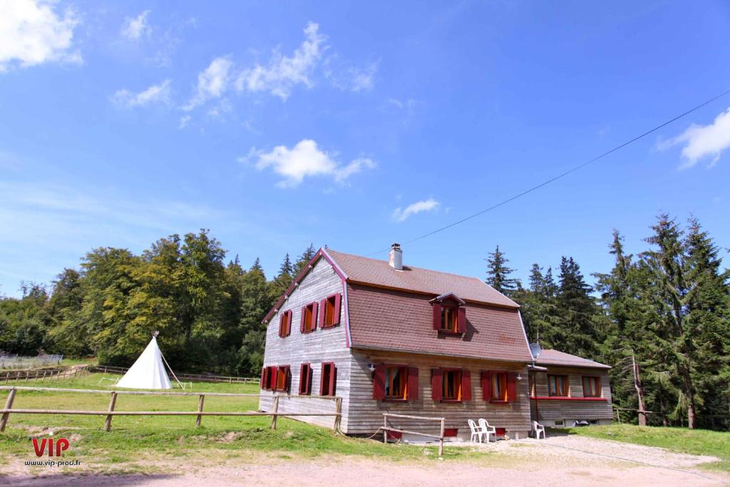 an old barn with red windows and a white tent at Les gîtes de la Serva in Belmont