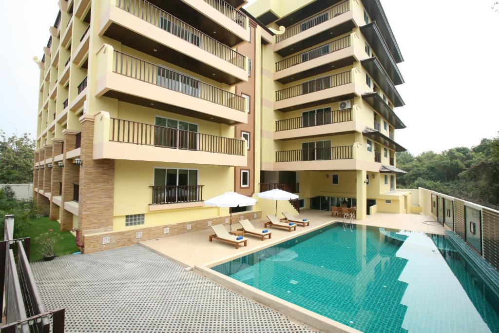 an apartment building with a swimming pool next to a building at Jomtien Beach Residence in Jomtien Beach
