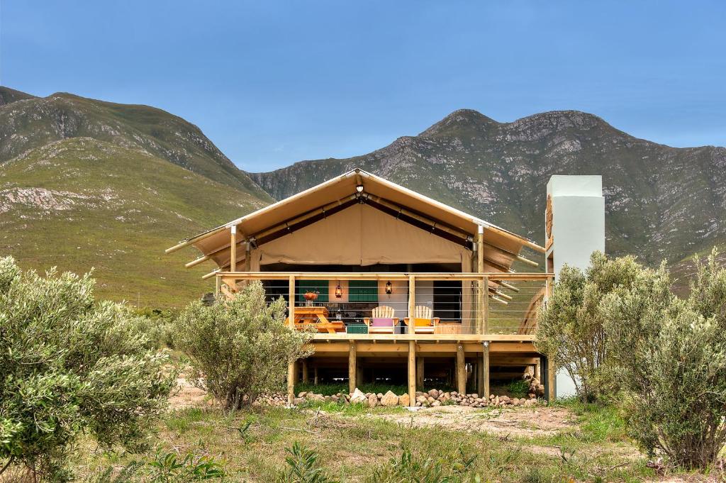 a house in the mountains with mountains in the background at AfriCamps at Stanford Hills in Stanford