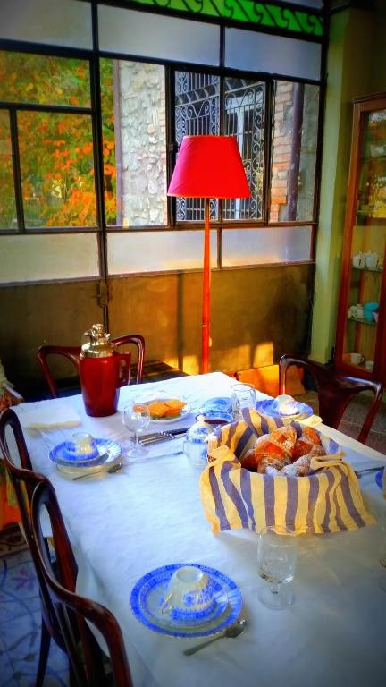 una tavola con piatti di cibo e una lampada rossa di Appartamenti Lais in Sipicciano a Sipicciano