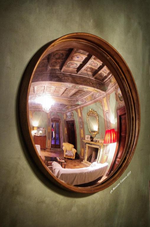 riflesso di una camera da letto in uno specchio rotondo di Appartamenti Lais in Sipicciano a Sipicciano