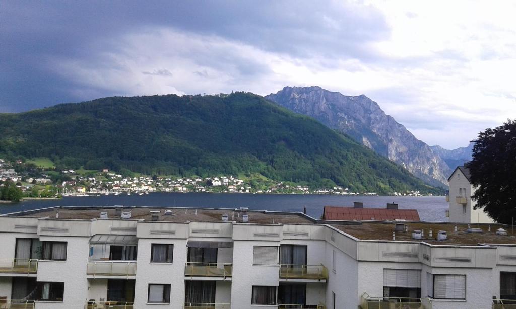 um edifício com vista para um lago e uma montanha em Vintage Garconiere mit Balkon - 25 m2 em Gmunden