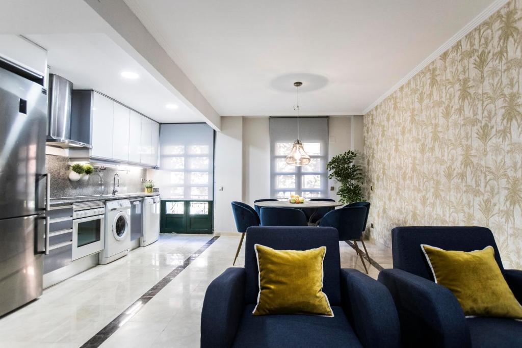 馬德里的住宿－Chamberí I，厨房以及带蓝色椅子和桌子的用餐室