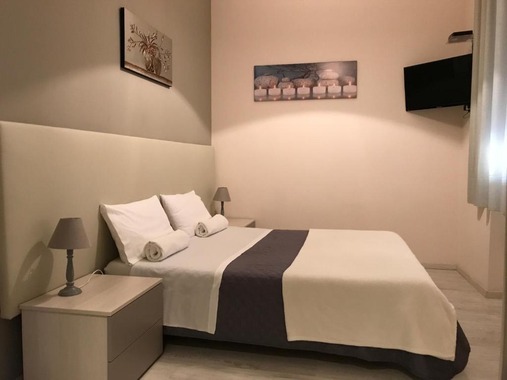1 dormitorio con 1 cama con sábanas y almohadas blancas en Civico7, en Villa San Giovanni