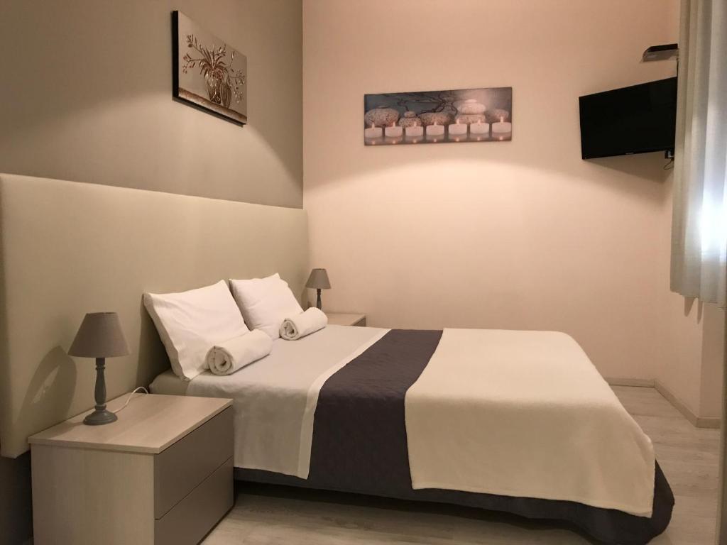a bedroom with a bed with white sheets and pillows at Civico7 in Villa San Giovanni