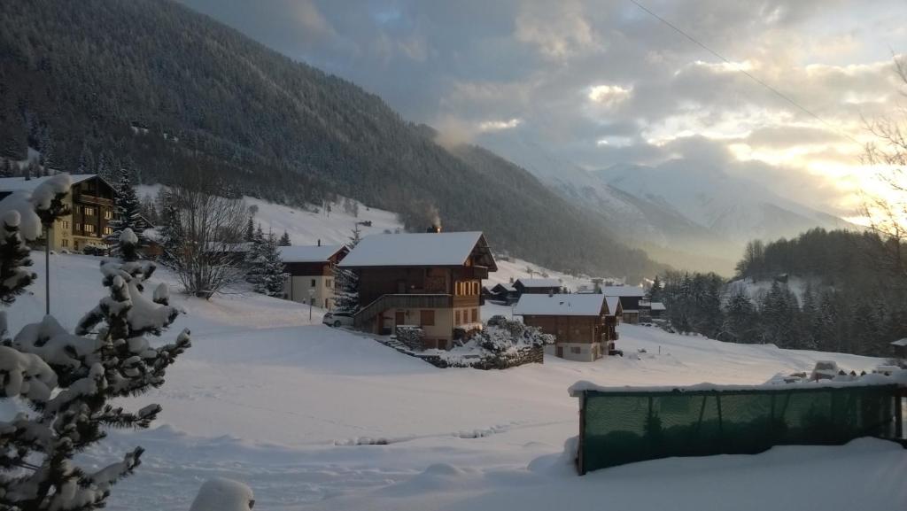 un pueblo cubierto de nieve con montañas en el fondo en Chalet Pinocchio, en Mühlebach