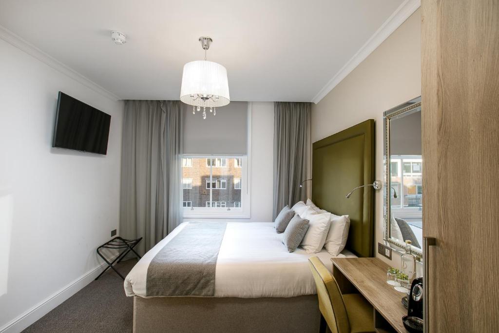sypialnia z łóżkiem, biurkiem i oknem w obiekcie Park Avenue J Hotel London Hyde Park w Londynie