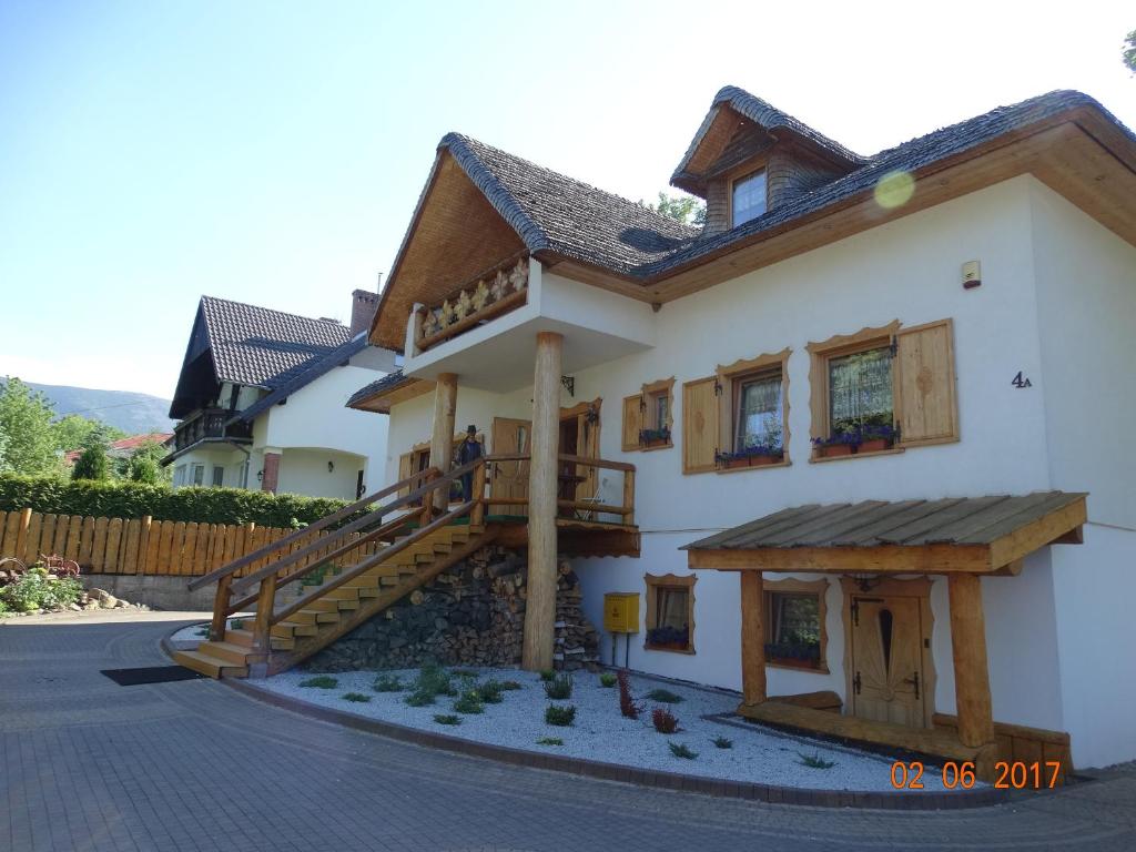 カルパチにあるDworek Karpaczの木製の階段が目の前にある家