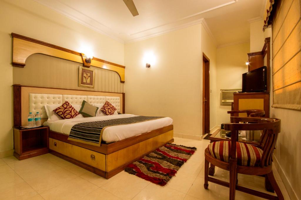 a bedroom with a bed and a chair at The C Park Inn Karol Bagh Homely Atmosphere in New Delhi