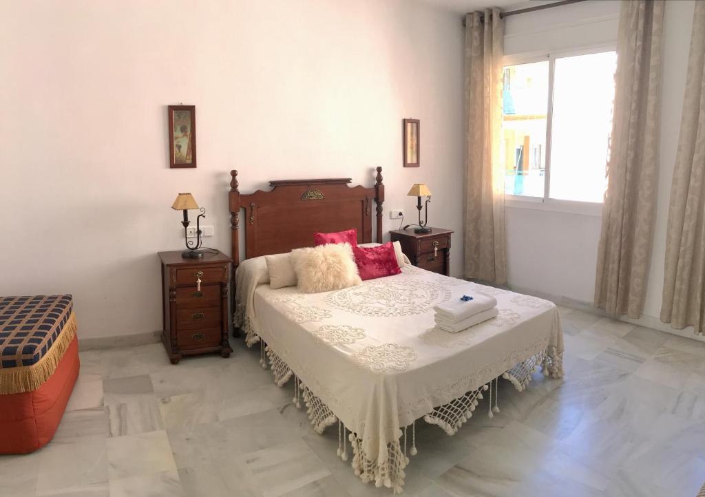セビリアにあるMagnífico apartamento en el centro de Sevillaのベッドルーム1室(ベッド1台、テーブル2台、窓付)