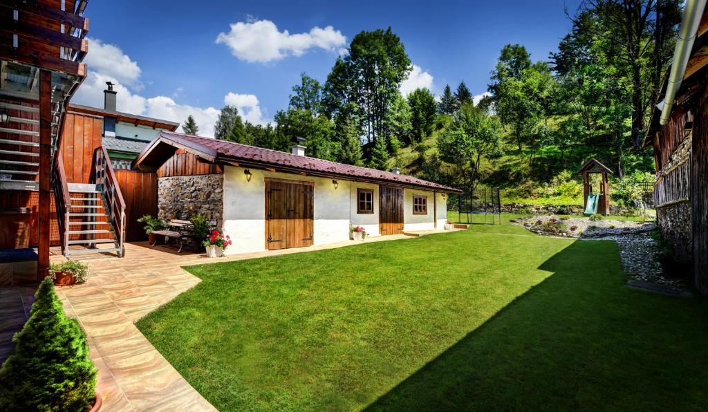 a garden with a house and a lawn at Apartmany Izbica in Červený Kláštor