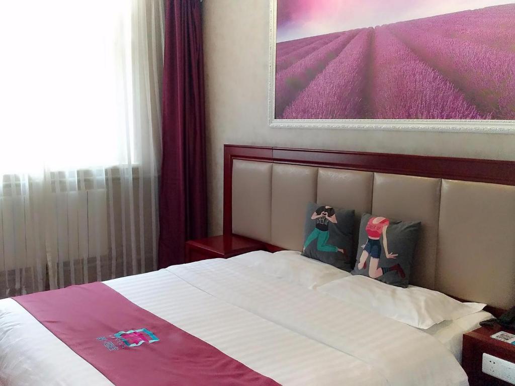 a bedroom with a bed with a picture on the wall at Pai Hotel Guiyang Fountain Modern Capital in Guiyang