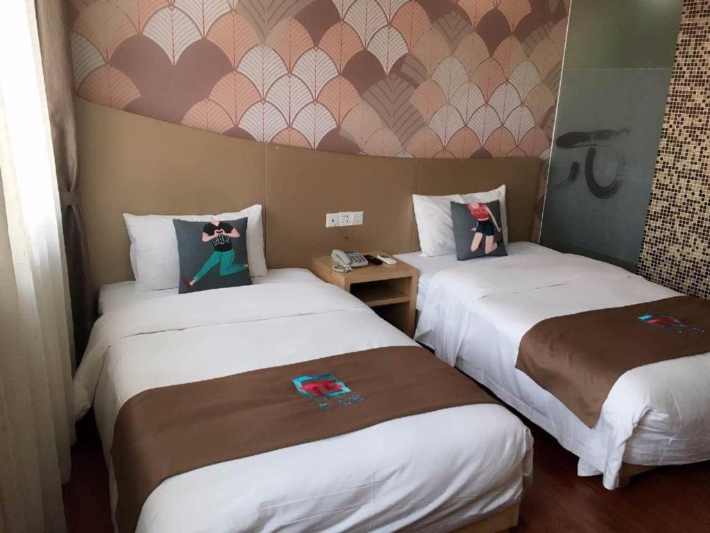 a hotel room with two beds in a room at Pai Hotel Beijing Shahe Subway Station in Baishan