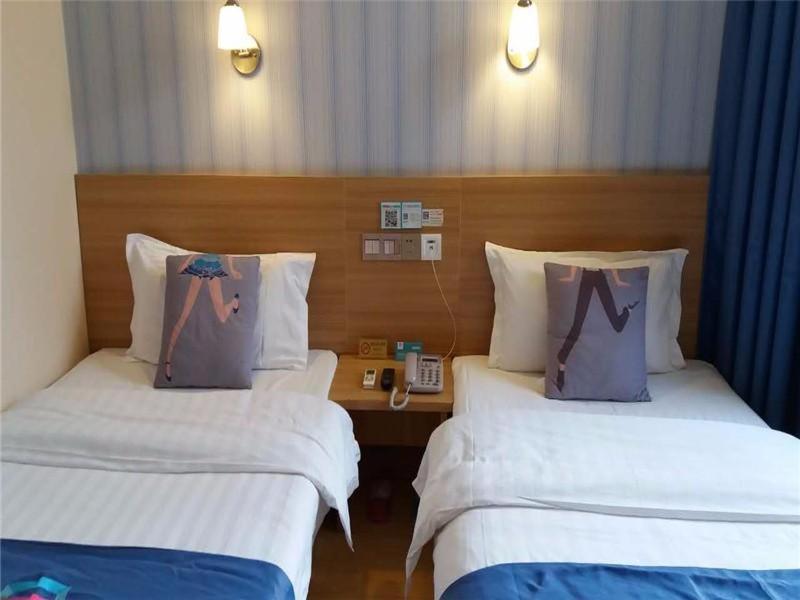 2 Betten mit Kissen in einem Hotelzimmer in der Unterkunft Pai Hotel Beijing Huaxiang Bridge Guogong Zhuang Subway Station in Peking