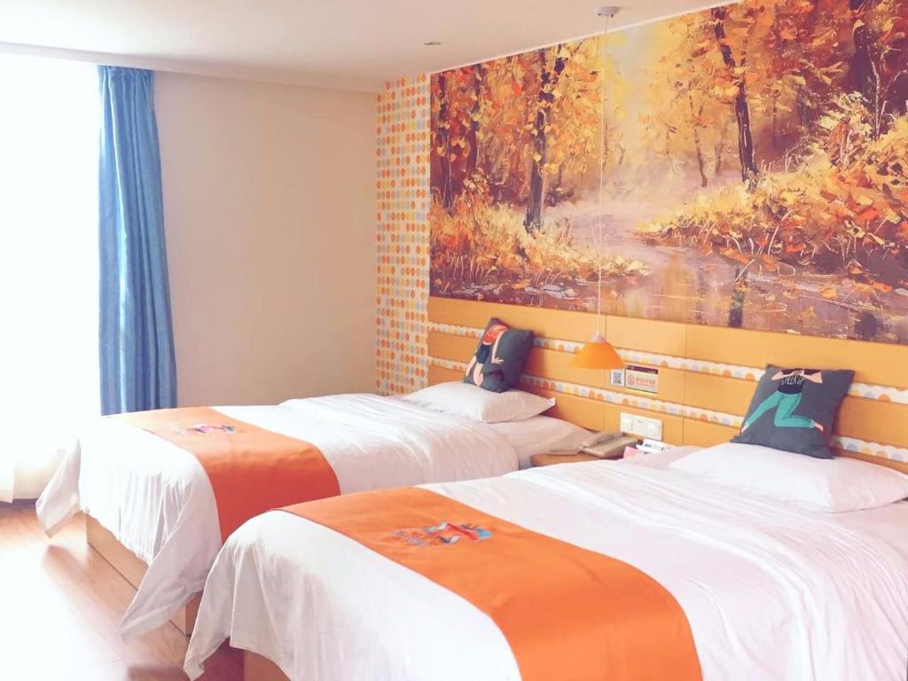 2 Betten in einem Zimmer mit Wandgemälde in der Unterkunft Pai Hotel Tangshan Gangyao Road Hebei Bridge in Tangshan