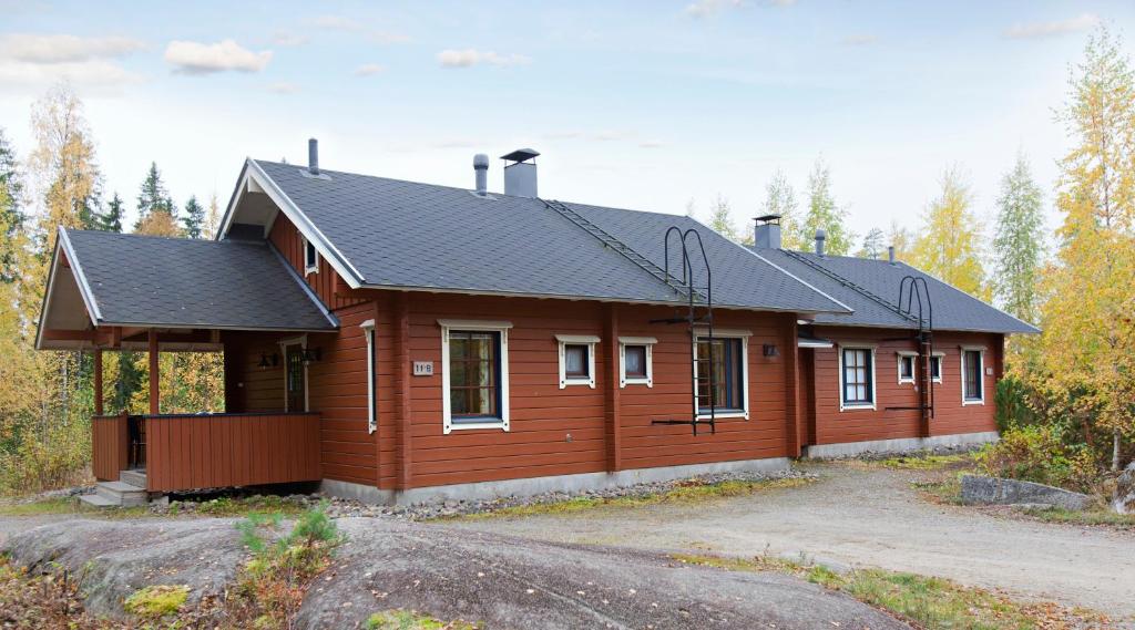a large wooden house with a black roof at Holiday Club Ähtäri Cottages in Ähtäri