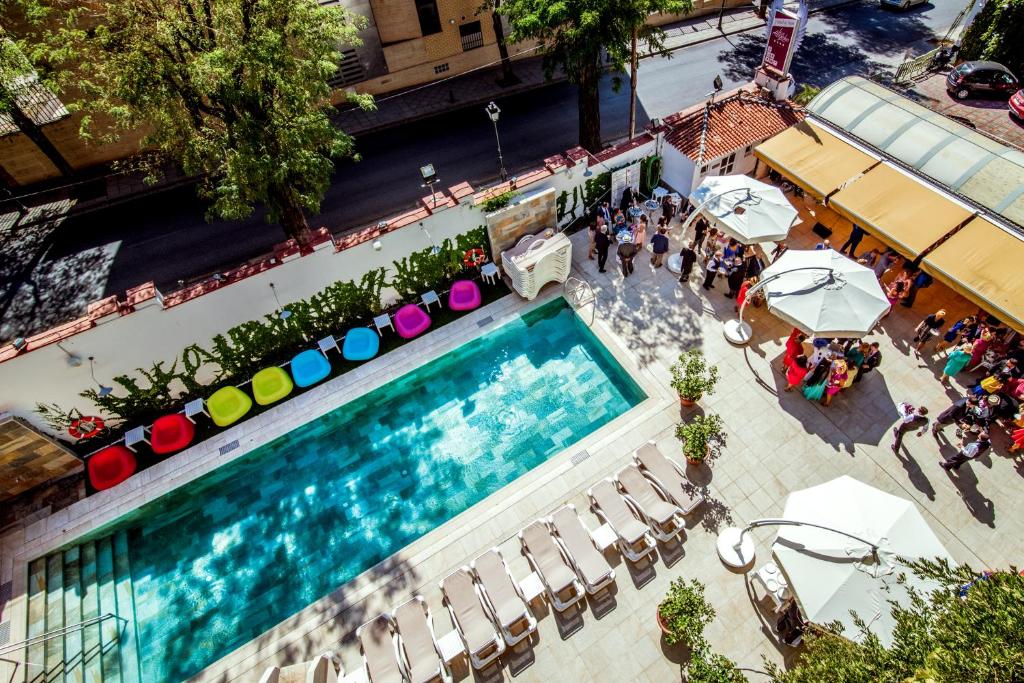 una vista sul tetto di una piscina con ombrelloni di Los Angeles Hotel & Spa a Granada