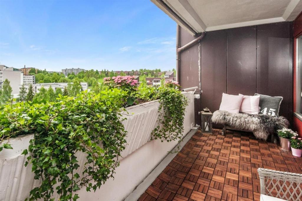 a balcony with a chair and plants on a building at Private Room Gransdalen in Oslo