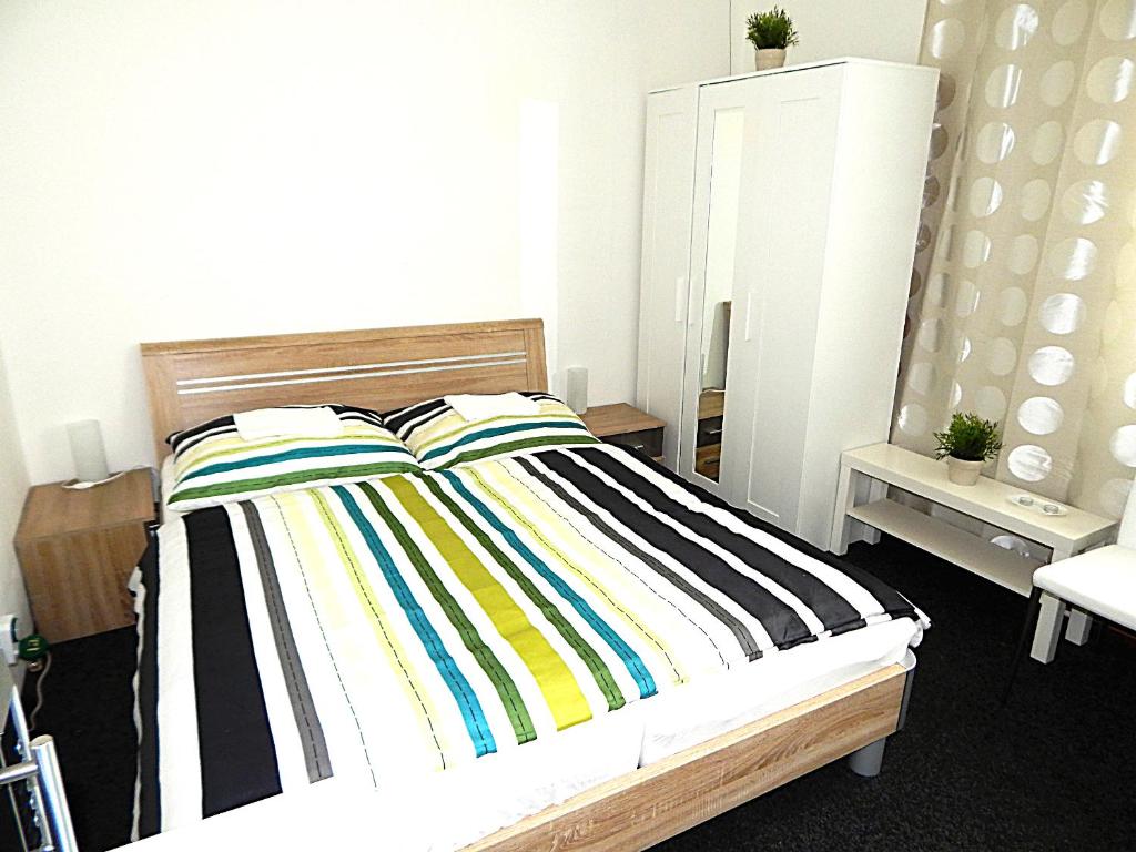 a bedroom with a bed with a colorful striped blanket at Apartments Ostrava Vítkovice in Ostrava