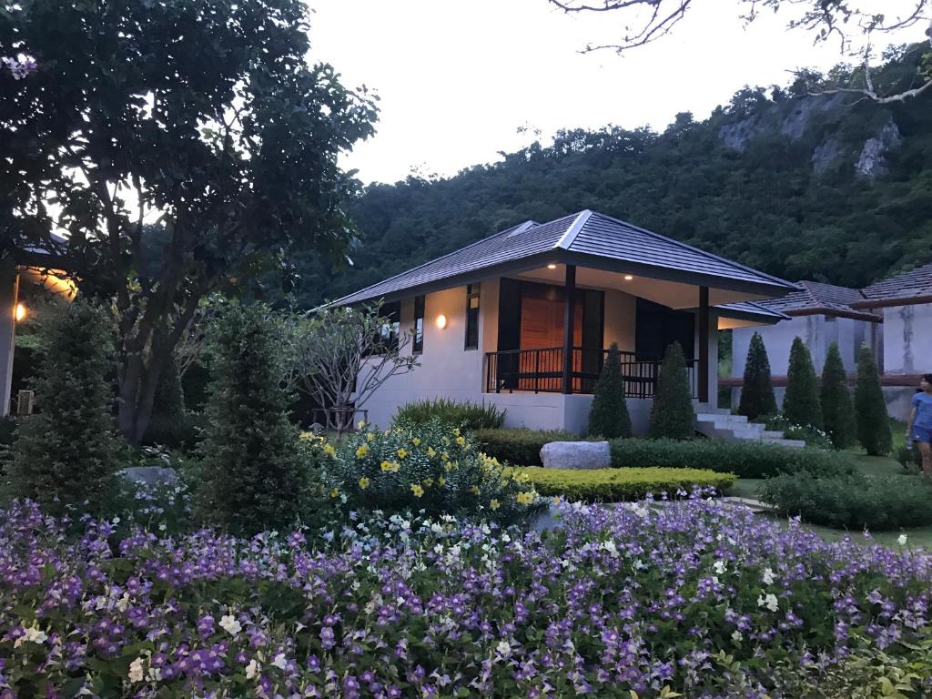 Khaokhab Lodge في Nong Nam Daeng: حديقة امام بيت به ورد