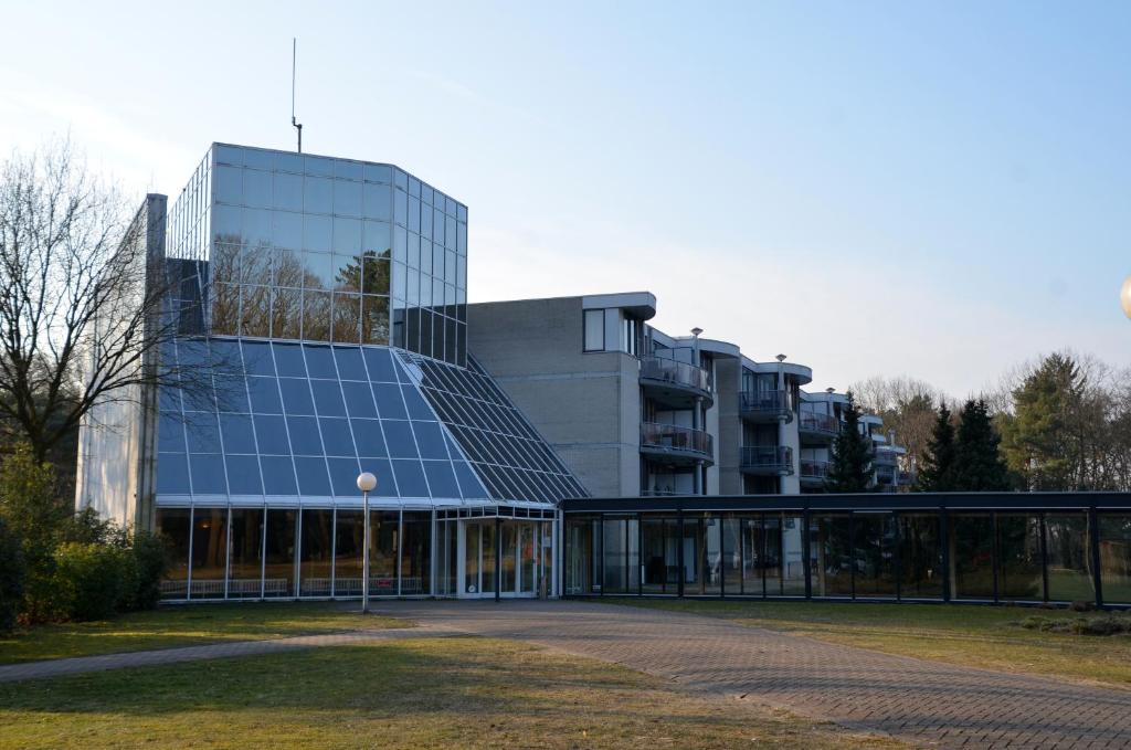 恩斯赫德的住宿－Appartementen Bad Boekelo，一座大型玻璃建筑,设有日光浴室