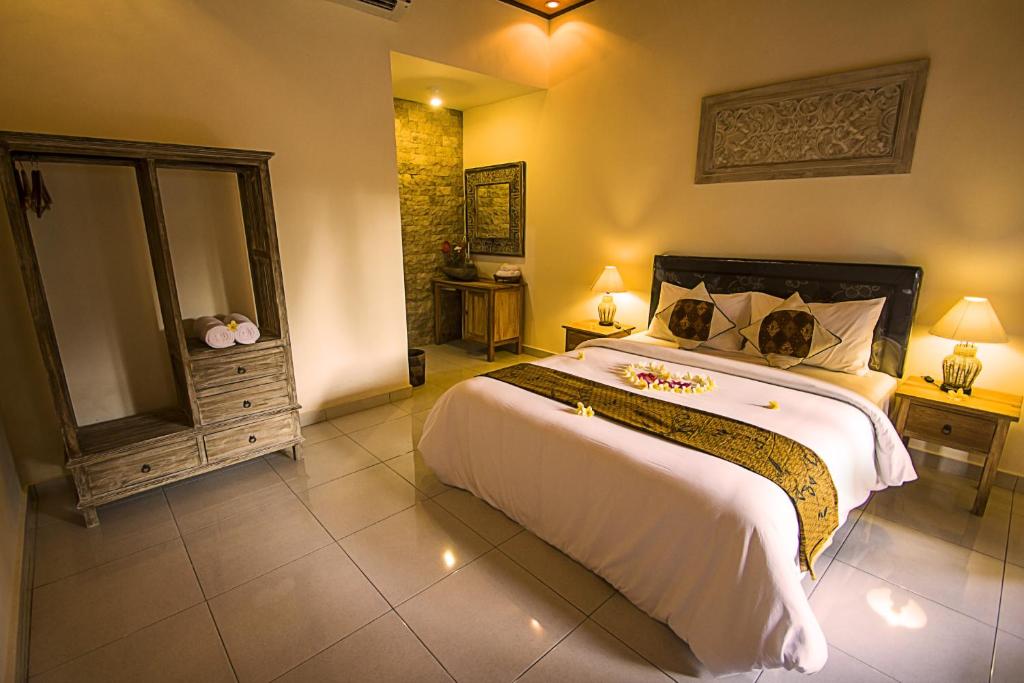 ein Schlafzimmer mit einem großen Bett in einem Zimmer in der Unterkunft Umah Dajane Guest House in Ubud