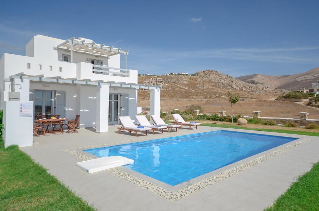 a villa with a swimming pool in front of a house at Natura Villas in Naxos in Mikri Vigla