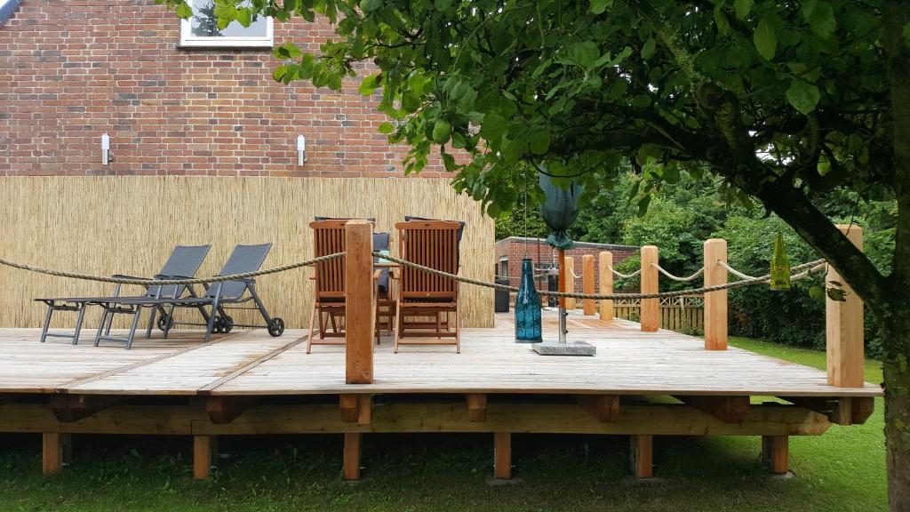 eine Holzterrasse mit Stühlen und einem Tisch in der Unterkunft Ferienhaus Martha in Fehmarn