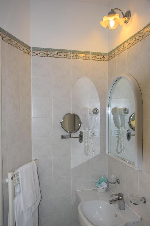 łazienka z umywalką i lustrem w obiekcie Hotel Italia w mieście Marina di Massa