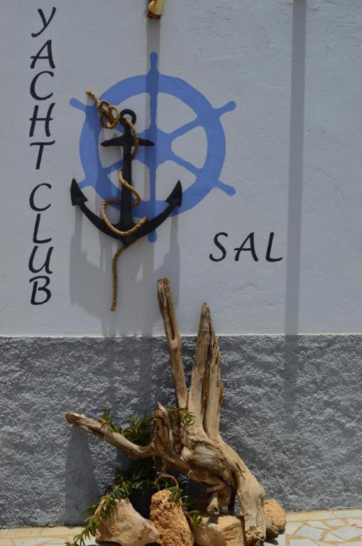 un cartello con un'ancora sul lato di un edificio di Yacht Club Sal a Palmeira