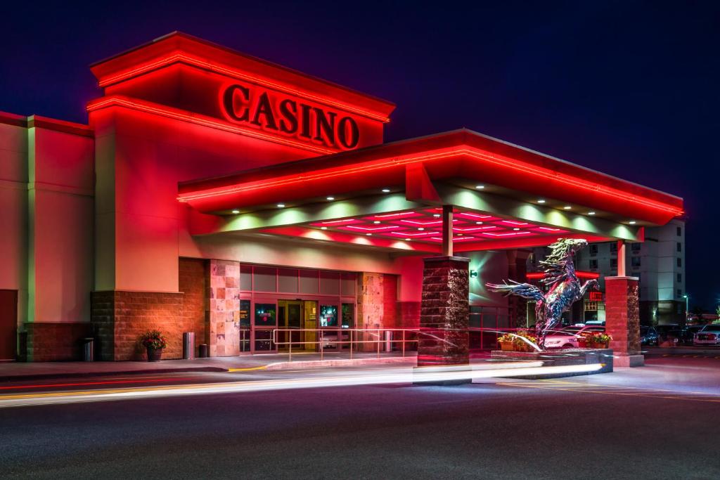 a gas station lit up at night with red lights at Deerfoot Inn and Casino in Calgary