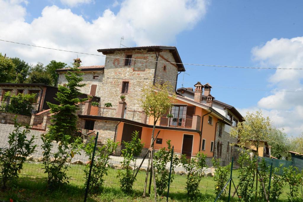 een oud stenen huis in een grasveld bij Torretta di Bassano in Rivergaro