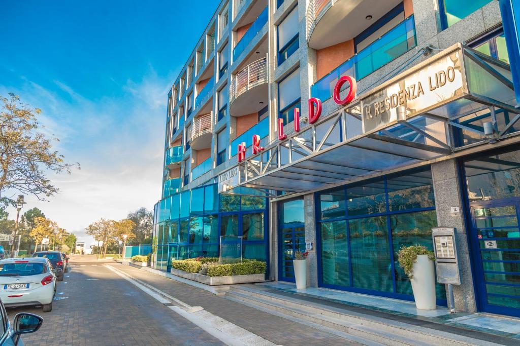 a building with a sign on it on a street at Lido Hotel Residence in Cesenatico