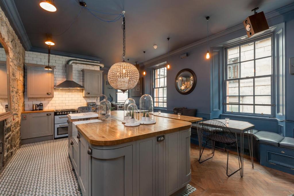 una grande cucina con pareti blu e una grande isola di The Baxter Hostel a Edimburgo