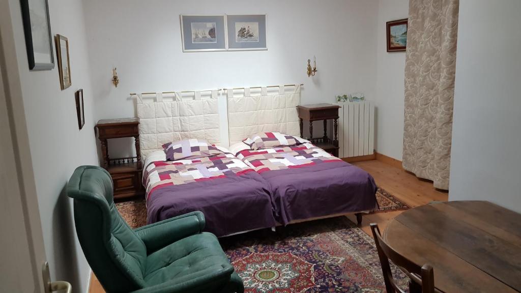 1 dormitorio con 1 cama, 1 silla y 1 mesa en Alain et Nicole, en Cognac