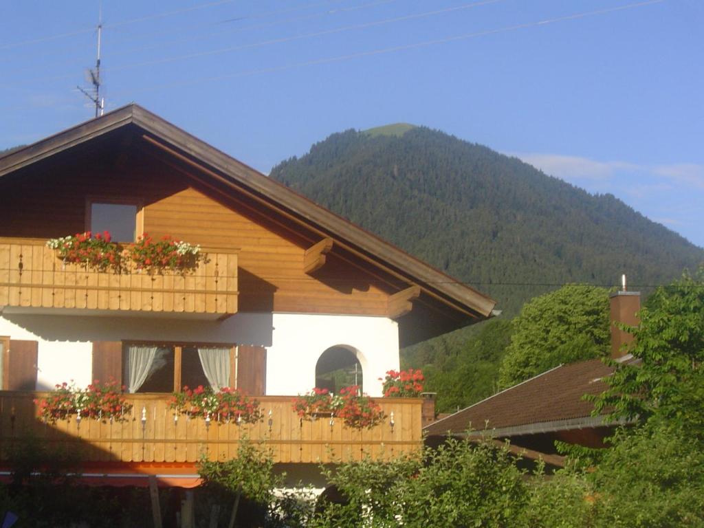 a house with a balcony with flowers on it at Gästehaus Peter Wiedemann in Lenggries