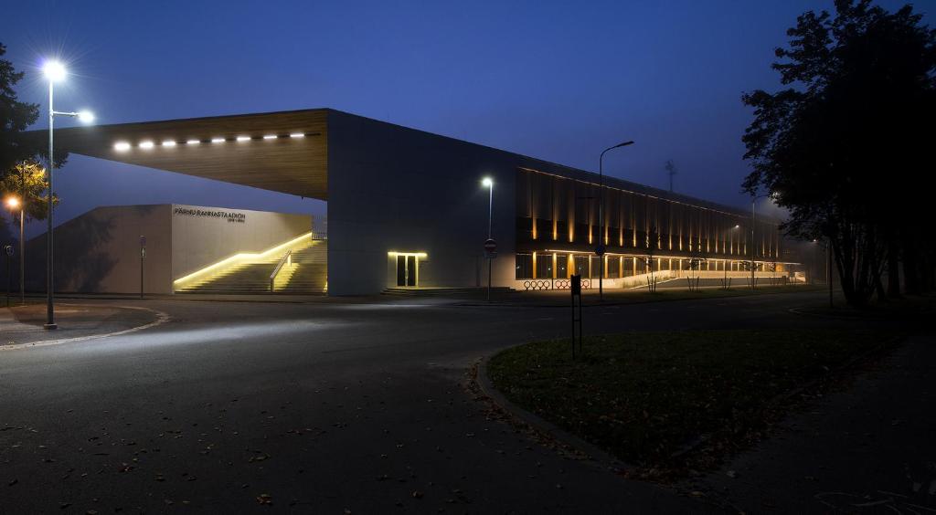 um edifício com luzes de lado à noite em Pärnu Rannastaadioni Hostel em Pärnu