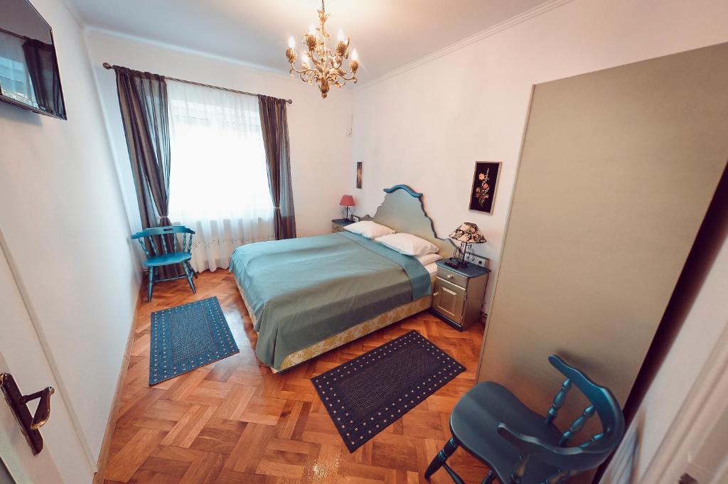 シビウにあるAntique Apartment Sibiuのベッドルーム1室(ベッド1台、椅子、窓付)