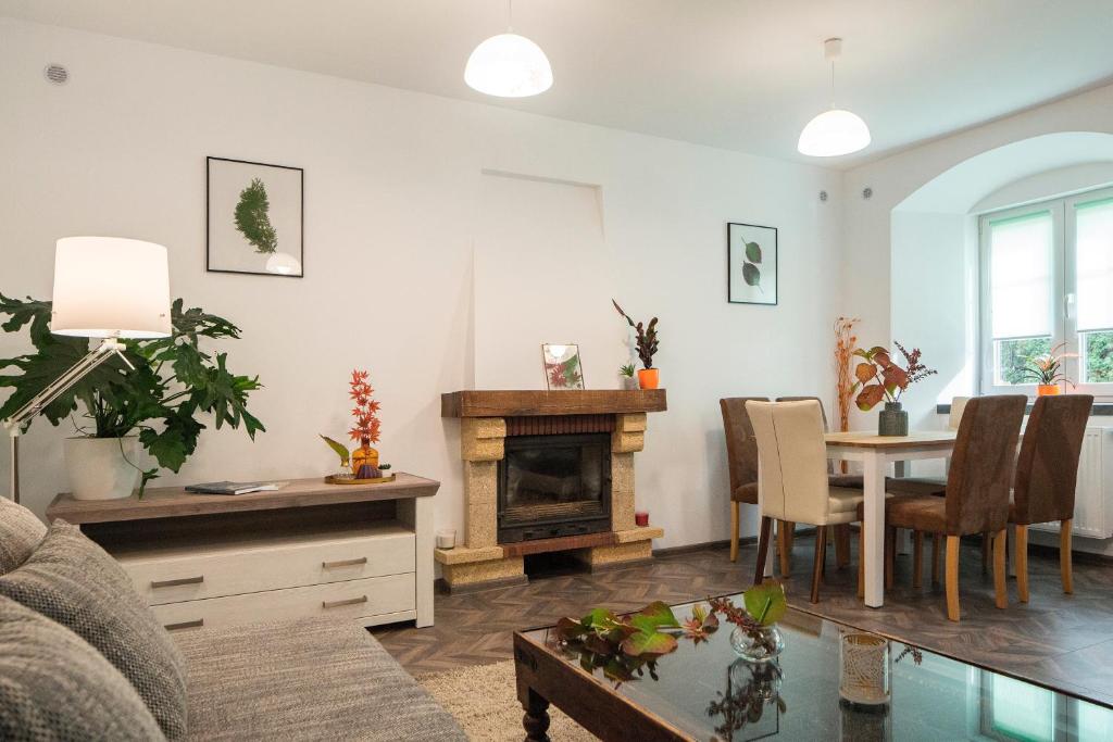 een woonkamer met een tafel en een open haard bij Apartment Schiller 3 in Braşov